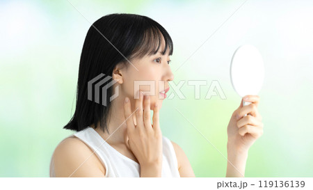 鏡で肌をチェックする若い女性・美容イメージ 鏡で肌をチェックする若い女性・美容イメージ 119136139