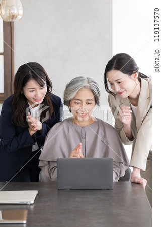 幅広い年齢層の女性チームで働く複数のビジネスマン ミーティングで業績を話合う、コミュニケーション 幅広い年齢層の女性チームで働く複数のビジネスマン ミーティングで業績を話合う、コミュニケーション 119137570