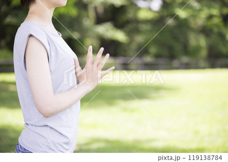 屋外で合掌をする若い女性　外ヨガイメージ 119138784