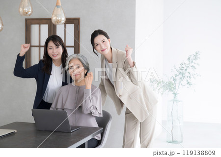 幅広い年齢層の女性チームで働く複数のビジネスマン カメラ目線の笑顔でガッツポーズ 幅広い年齢層の女性チームで働く複数のビジネスマン カメラ目線の笑顔でガッツポーズ 119138809