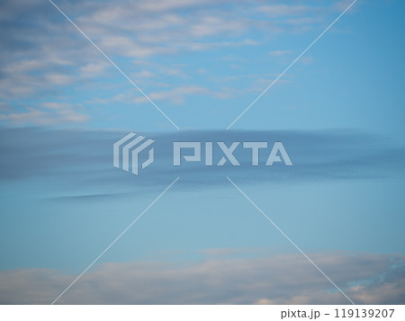 Beautiful blue sky with white Altocumulus and cirrus clouds in dusk, clouds are painted pink in the sunset 119139207