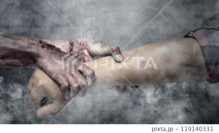 A zombie hand with a bloody wound grabs a human hand in dark room. Scene has dark and scary. Zombie, devil, evil, satan, or monster hands A zombie hand with a bloody wound grabs a human hand in dark room. Scene has dark and scary. Zombie, devil, evil, satan, or monster hands 119140331