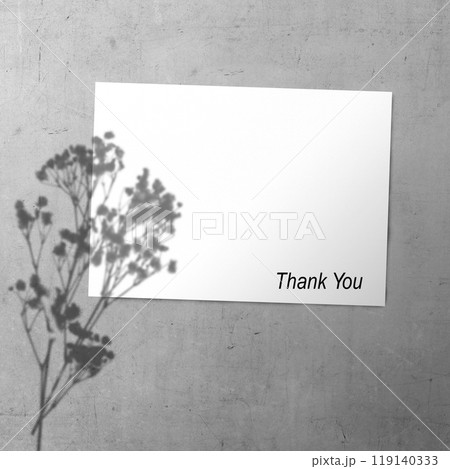 White paper with flowers shadow and words "Thank You" written on it. The paper is hanging on wall White paper with flowers shadow and words "Thank You" written on it. The paper is hanging on wall 119140333