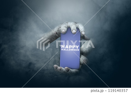 Mummy hands have dirty bandages on them. Mummy, devil, evil, satan, or zombie hands holding a mobile phone with a Happy Halloween sign Mummy hands have dirty bandages on them. Mummy, devil, evil, satan, or zombie hands holding a mobile phone with a Happy Halloween sign 119140357