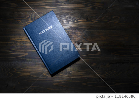 Blue book with the word Holy Bible on the front. Christian background, worship, church, symbols, praying concept. Symbol of faith in God, Christianity Feast, Easter, Good Friday, Palm Sunday 119140396