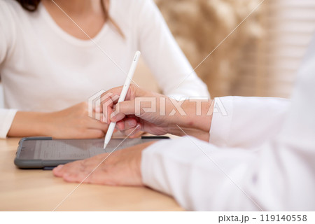 Young woman patient consultation with senior doctor about illness while watching tablet. Young woman patient consultation with senior doctor about illness while watching tablet. 119140558