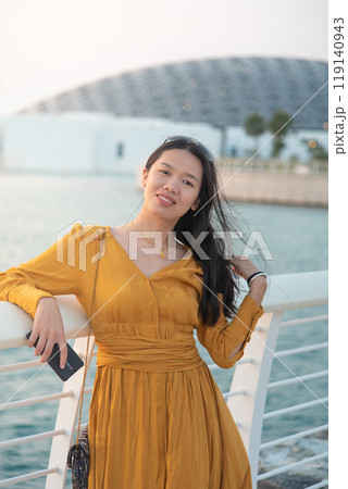 Asian woman standing in front of Louvre Abu Dhabi Asian woman standing in front of Louvre Abu Dhabi 119140943