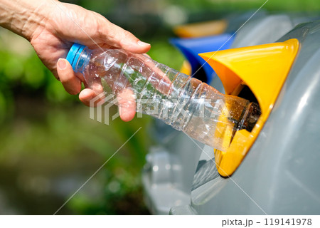 Please dispose of plastic bottle into the tank. A man throw rubbish in the trash can by separate garbage to dispose like hazardous waste , 119141978