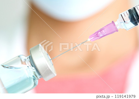Doctor's hand holds a syringe and a blue vaccine covid19 bottle at the hospital. Health and medical concepts Doctor's hand holds a syringe and a blue vaccine covid19 bottle at the hospital. Health and medical concepts 119141979