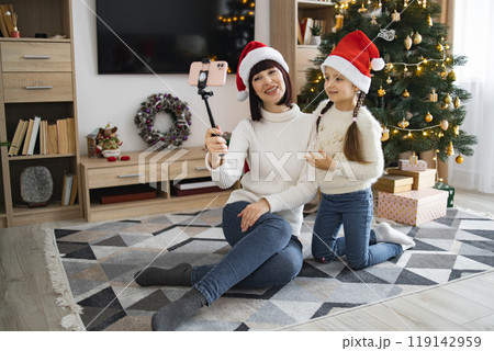 Mom and daughter video call in front of Christmas tree Mom and daughter video call in front of Christmas tree 119142959