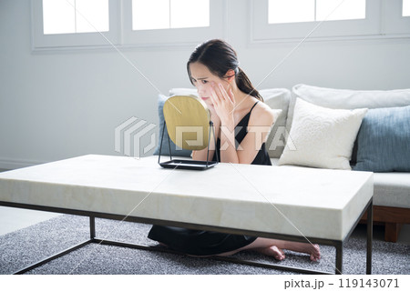 鏡を見て肌の調子を悩む気にする女性の広角 119143071