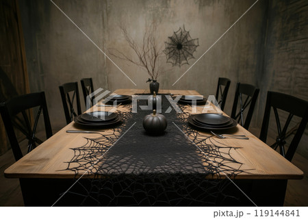Eerie Halloween table setting with black plates, candles, spiderweb decor on dimly lit background. Spooky dining concept Eerie Halloween table setting with black plates, candles, spiderweb decor on dimly lit background. Spooky dining concept 119144841