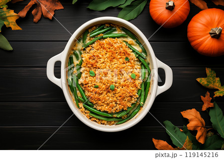 Green bean casserole topped with crispy onions in ceramic dish on wooden background. Thanksgiving Day side dishes 119145216