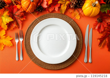 Empty white plate with fork and knife, surrounded by pumpkins, leaves on red background. Thanksgiving concept 119145218