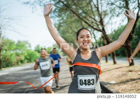 woman marathon runner crossing finish line woman marathon runner crossing finish line 119148052