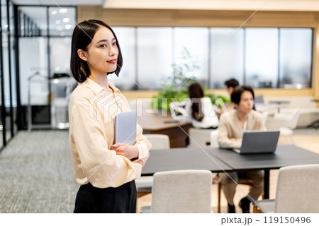 ノートパソコンを抱えて視線を送るビジネスパーソン 119150496