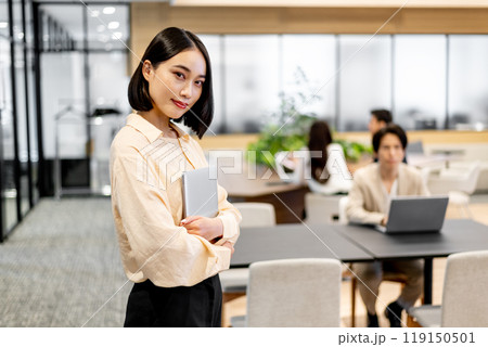 ノートパソコンを抱えながら視線を送るビジネスパーソン ノートパソコンを抱えながら視線を送るビジネスパーソン 119150501