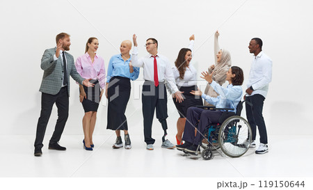 Diverse group of business professionals, including person in wheelchair and man with prosthetic leg, celebrate success with raised hands. 119150644