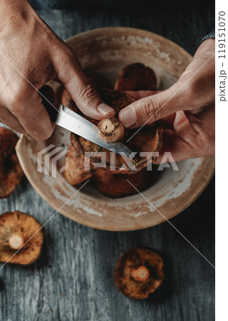 man cutting the stem of some catalan rovellons man cutting the stem of some catalan rovellons 119151070