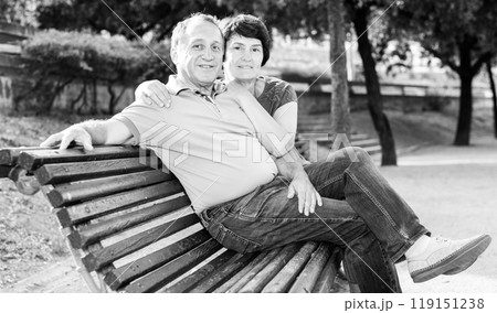 Middleaged male and female posing on bench 119151238