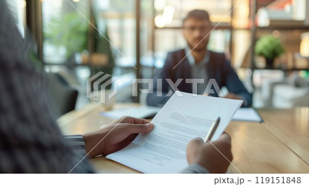 Job Interview in Modern Office, Candidate Meeting with Interviewer Holding Document in Blurred Background Setting Job Interview in Modern Office, Candidate Meeting with Interviewer Holding Document in Blurred Background Setting 119151848