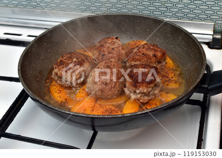The cutlets are fried in a frying pan. 119153030