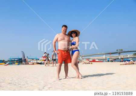 Photo from a beach holiday of a married couple, adults in bathing suits standing on the beach 119153889