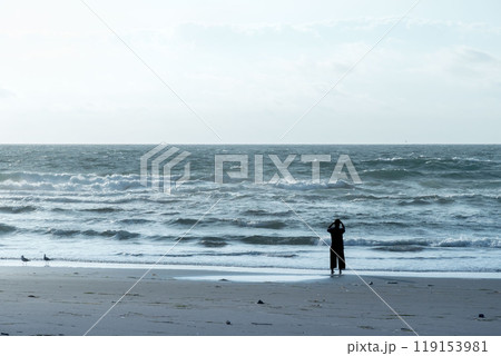 早朝の海岸を散歩する女性のシルエット 早朝の海岸を散歩する女性のシルエット 119153981