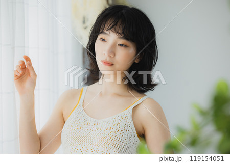 カーテンを開ける女性  119154051