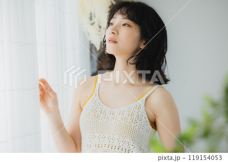 カーテンを開ける女性  119154053