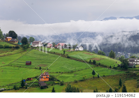 Misty morning in Vorokhta village with scenic view of Carpathian hills and fog-covered mountains 119154062