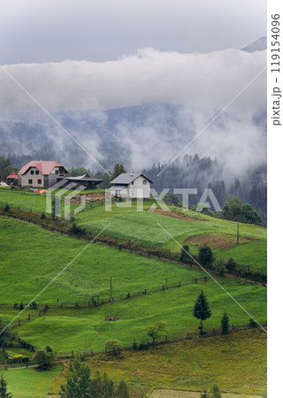 Misty morning in Vorokhta village with scenic view of Carpathian hills and fog-covered mountains 119154096