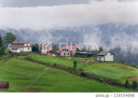 Misty morning in Vorokhta village with scenic view of Carpathian hills and fog-covered mountains 119154098