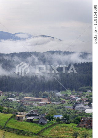 Misty morning in Vorokhta village with scenic view of Carpathian hills and fog-covered mountains 119154099