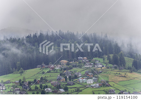 Misty morning in Vorokhta village with scenic view of Carpathian hills and fog-covered mountains 119154100