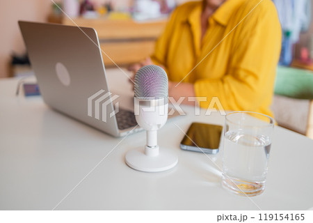 Female podcaster use smartphone and speaking with audience on microphone to recording video podcast. Female podcaster use smartphone and speaking with audience on microphone to recording video podcast. 119154165