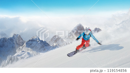 Snowboarder running downhill on sunny alpine slope 119154856