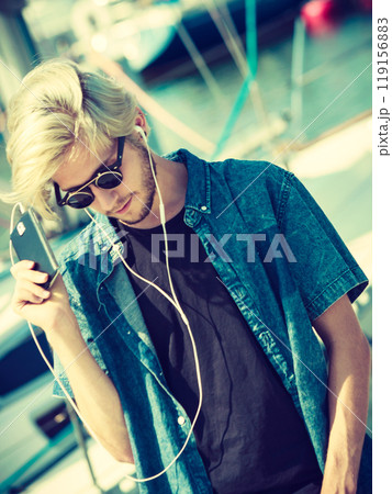 Blonde man in sunglasses listening to music 119156883