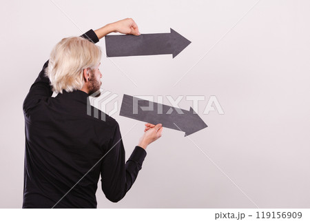 Man holding two arrows pointing same direction Man holding two arrows pointing same direction 119156909