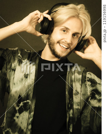 Blonde man singing in studio wearing headphones Blonde man singing in studio wearing headphones 119156998