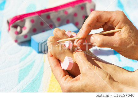 Woman pushing cuticles before pedicure Woman pushing cuticles before pedicure 119157040