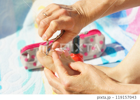 Woman trimming cuticles before pedicure 119157043