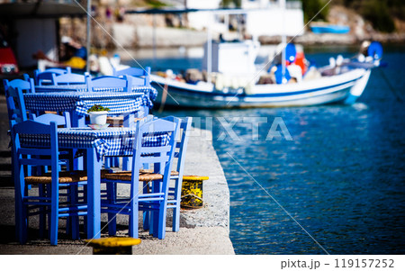 Open cafe outdoor restaurant in Greece on sea shore 119157252