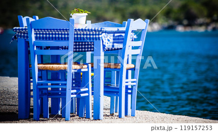 Open cafe outdoor restaurant in Greece on sea shore 119157253