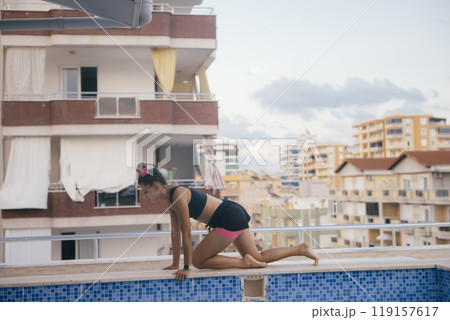 A Dedicated Fitness Enthusiast Engaging in a Challenging Workout Session on a Balcony A Dedicated Fitness Enthusiast Engaging in a Challenging Workout Session on a Balcony 119157617