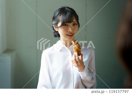 朝の落ち着いた雰囲気の中で一杯のコーヒーを飲む若い女性 119157797