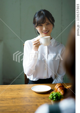朝の落ち着いた雰囲気の中で一杯のコーヒーを飲む若い女性 119157803