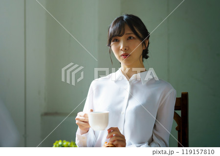 朝の落ち着いた雰囲気の中で一杯のコーヒーを飲む若い女性 朝の落ち着いた雰囲気の中で一杯のコーヒーを飲む若い女性 119157810