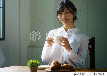 朝の落ち着いた雰囲気の中で一杯のコーヒーを飲む若い女性 朝の落ち着いた雰囲気の中で一杯のコーヒーを飲む若い女性 119157811