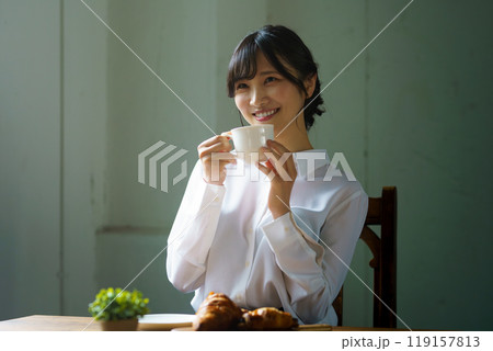 朝の落ち着いた雰囲気の中で一杯のコーヒーを飲む若い女性 朝の落ち着いた雰囲気の中で一杯のコーヒーを飲む若い女性 119157813